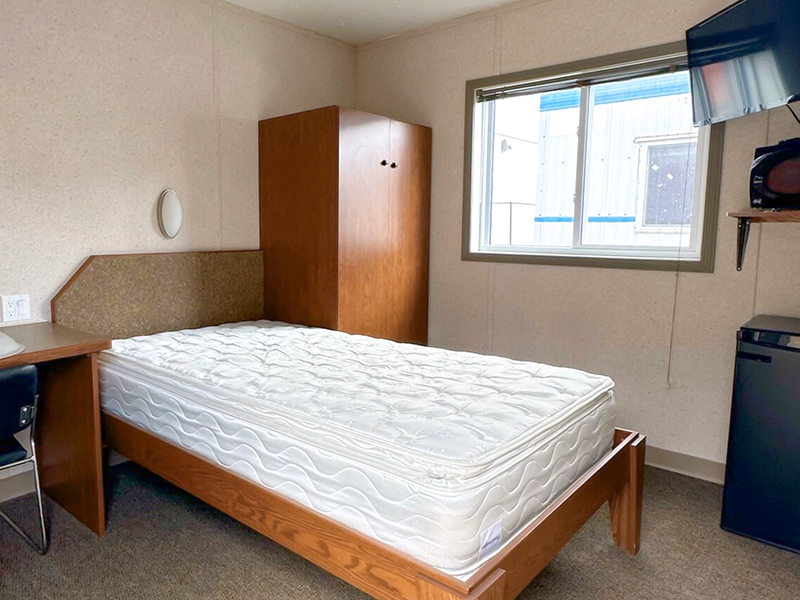 Untapped Modulars dorm unit with a bed, desk, dresser, and mini fridge