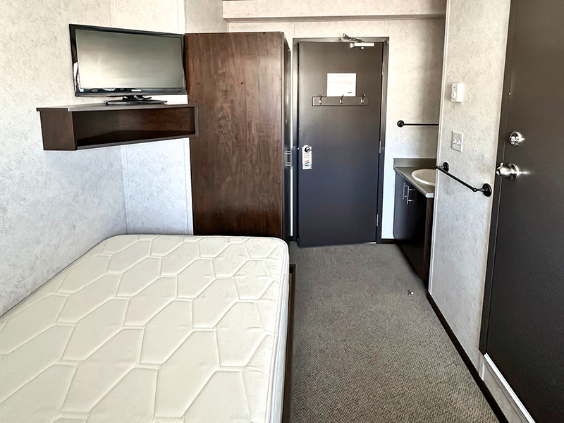 Untapped Modulars dorm unit with a bed, TV, and sink