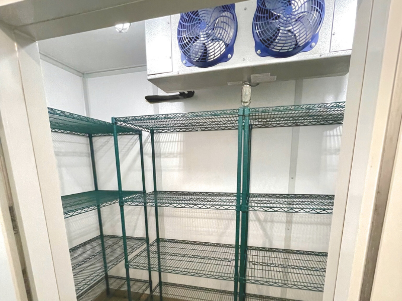 Commercial modular kitchen cooling room with fans and green shelves