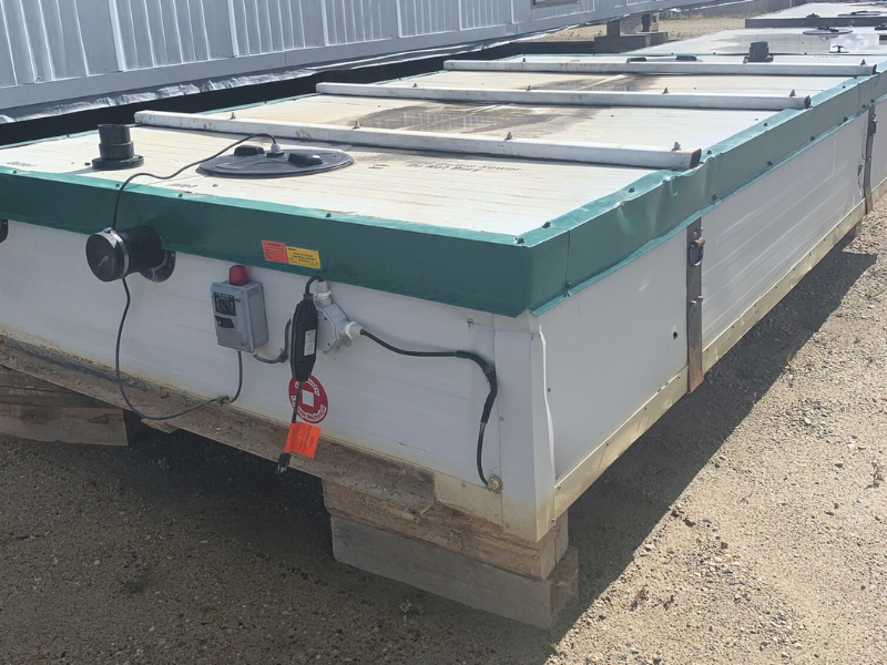 Rectangular holding tanks on a dirt ground