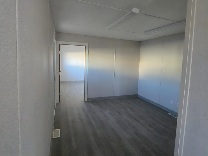 Empty modular office with light walls and wood grain flooring